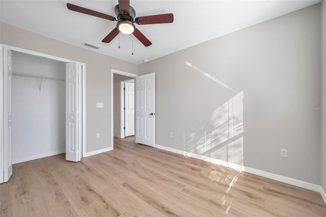 unfurnished bedroom featuring light wood-type flooring, ceiling fan, and a closet