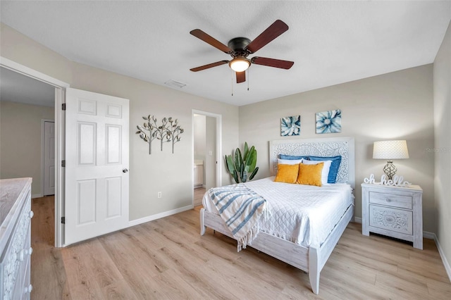 bedroom with ensuite bath, ceiling fan, and light hardwood / wood-style flooring