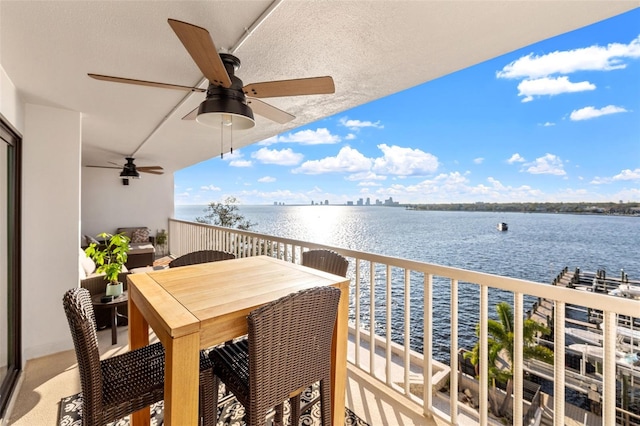 balcony with a water view and ceiling fan