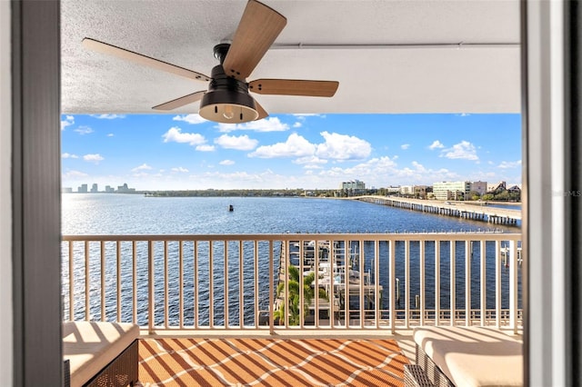 balcony with a water view and ceiling fan