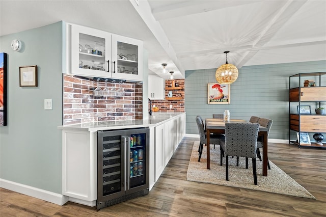 dining room with beamed ceiling, dark hardwood / wood-style floors, bar area, and wine cooler