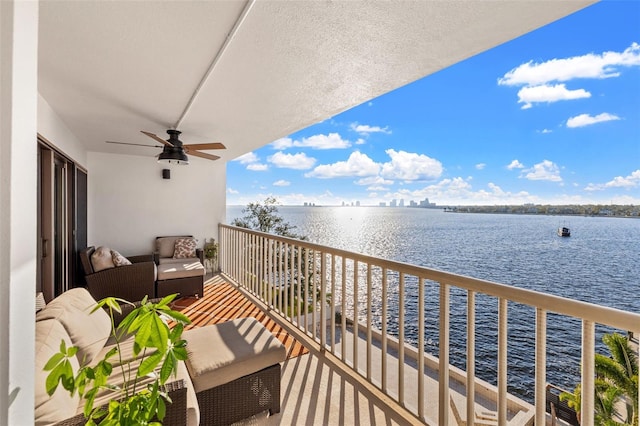 balcony with a water view and ceiling fan