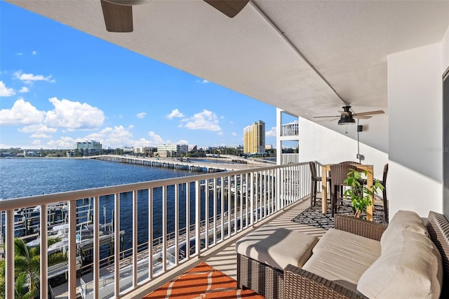 balcony featuring a water view, an outdoor hangout area, and ceiling fan