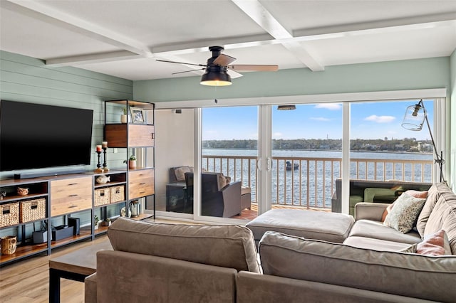 living room with beamed ceiling, a water view, hardwood / wood-style floors, and wooden walls