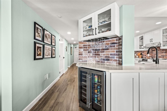 bar with sink, dark hardwood / wood-style flooring, beverage cooler, decorative backsplash, and white cabinets