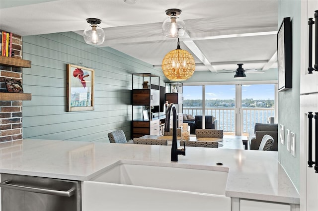 kitchen with wood walls, sink, coffered ceiling, stainless steel dishwasher, and light stone countertops