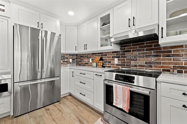 kitchen featuring white cabinetry, stainless steel appliances, tasteful backsplash, extractor fan, and light hardwood / wood-style floors