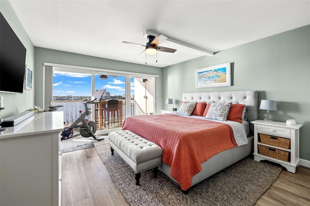 bedroom featuring beam ceiling, light wood-type flooring, access to outside, and ceiling fan