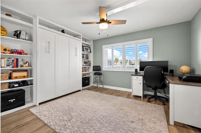 office with light hardwood / wood-style flooring, ceiling fan, and built in shelves