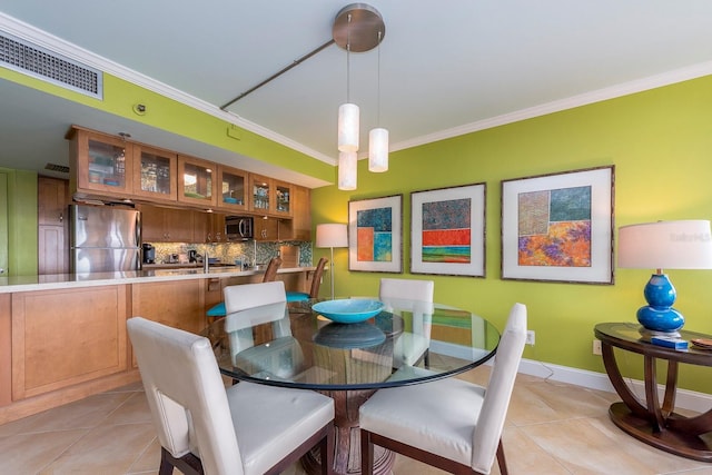 dining space featuring crown molding and light tile patterned flooring