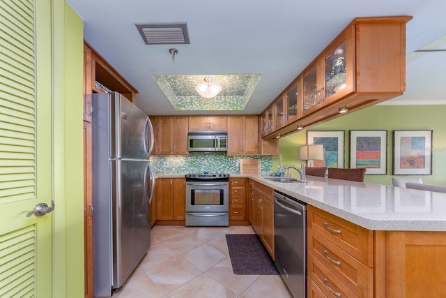 kitchen with tasteful backsplash, sink, light tile patterned floors, light stone counters, and stainless steel appliances