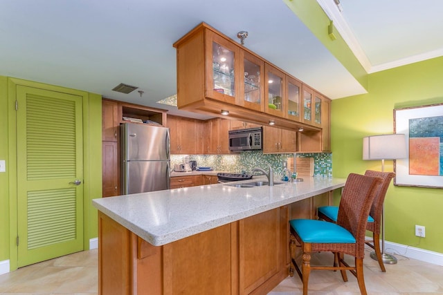 kitchen featuring sink, backsplash, kitchen peninsula, stainless steel appliances, and crown molding