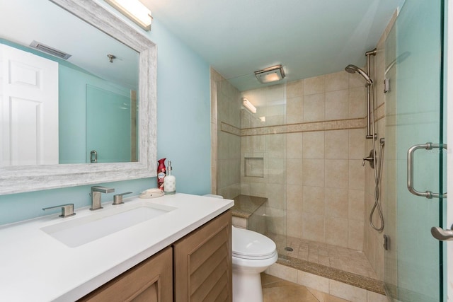 bathroom featuring vanity, toilet, tile patterned flooring, and a shower with door