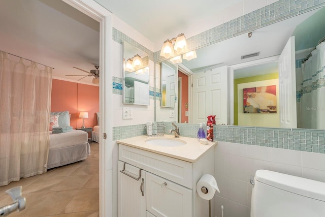 bathroom featuring ceiling fan, tile patterned floors, tile walls, and vanity