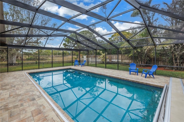 view of swimming pool featuring a lanai, a lawn, and a patio area