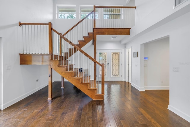 entrance foyer with dark wood-type flooring, french doors, and a towering ceiling