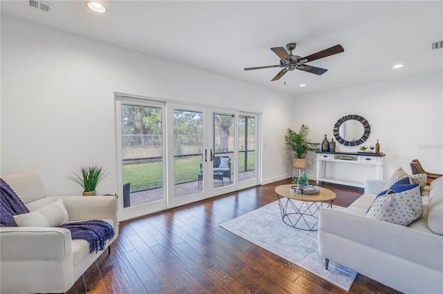 living room featuring ceiling fan and dark wood-type flooring