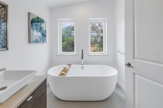 bathroom featuring tile patterned flooring, a bathtub, and vanity