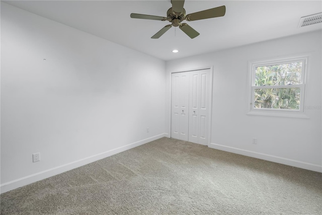 unfurnished bedroom with ceiling fan, a closet, and carpet floors