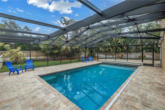 view of pool with a patio area and glass enclosure