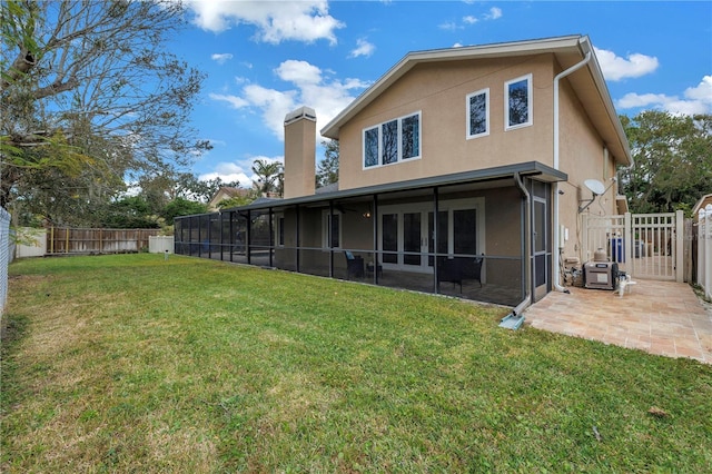 back of property with a yard, a patio, and a sunroom