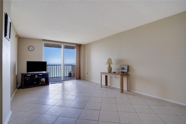 unfurnished living room with a textured ceiling, expansive windows, and light tile patterned floors