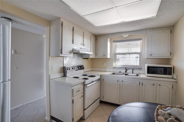 kitchen with white appliances, light tile patterned floors, and sink