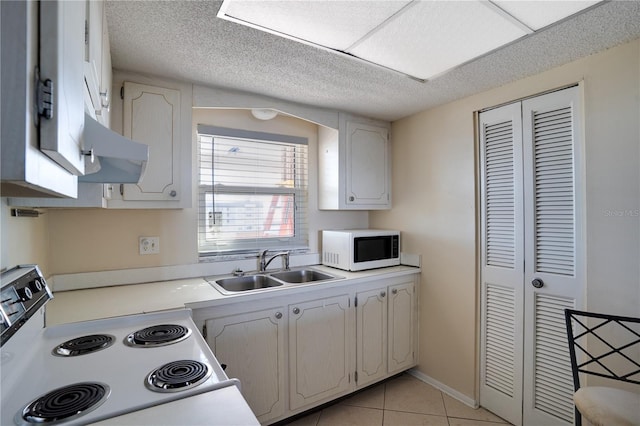 kitchen featuring sink, range with electric cooktop, white cabinets, and light tile patterned floors