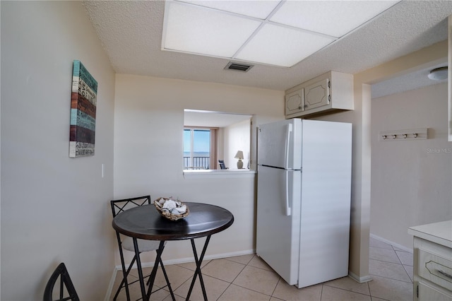 kitchen with white fridge and light tile patterned floors