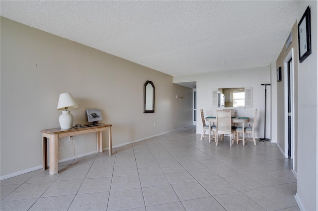 dining space with a textured ceiling and light tile patterned flooring