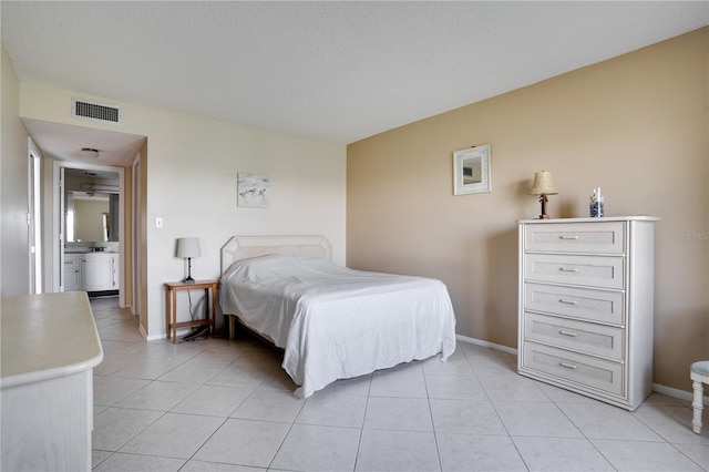 bedroom with ensuite bath and light tile patterned floors