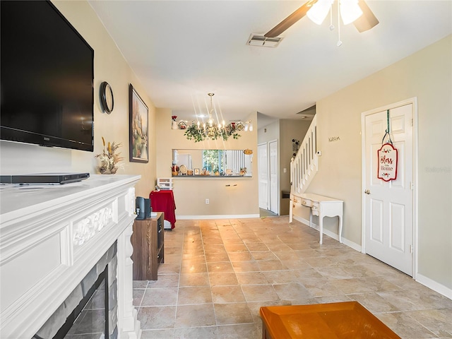 living room with ceiling fan with notable chandelier