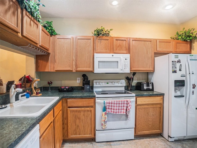 kitchen featuring a textured ceiling, white appliances, and sink