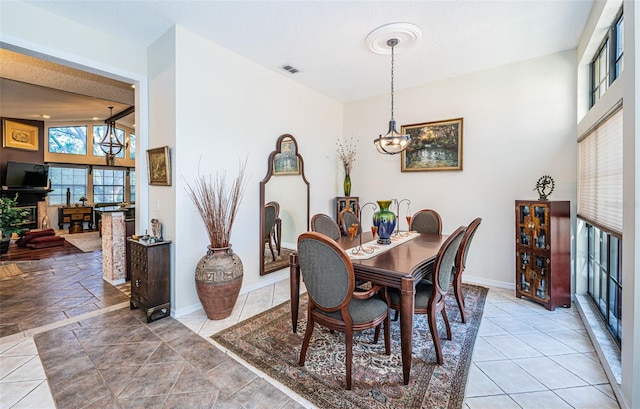 dining area featuring an inviting chandelier, lofted ceiling, and light tile patterned floors