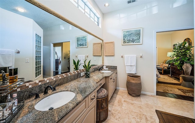 bathroom with a high ceiling and vanity