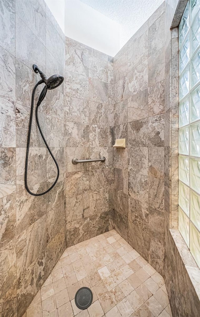 bathroom featuring a tile shower and a textured ceiling