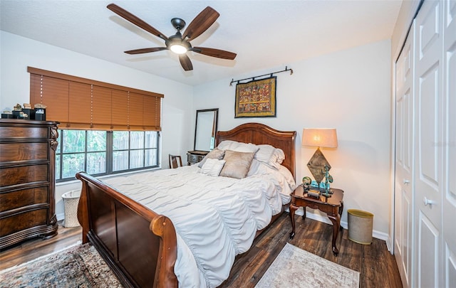 bedroom featuring dark wood-type flooring, ceiling fan, and a closet