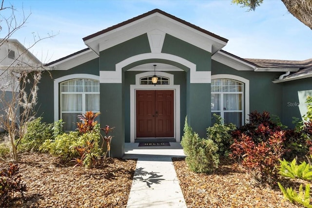 view of exterior entry featuring stucco siding