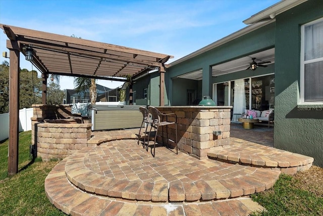 view of patio / terrace featuring exterior kitchen, a pergola, and a hot tub