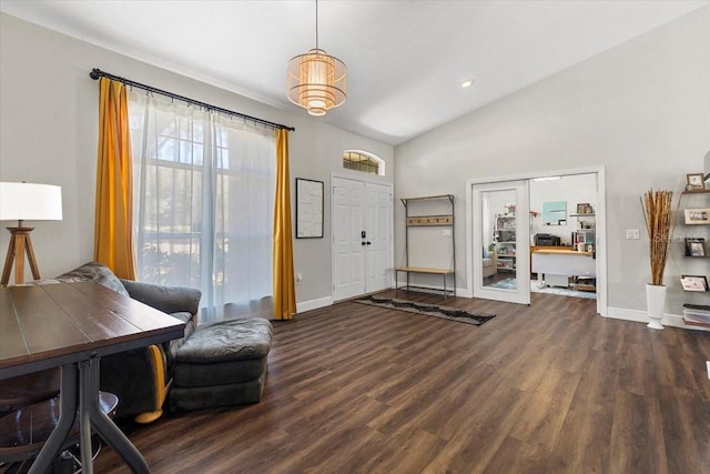 foyer featuring lofted ceiling, wood finished floors, and baseboards