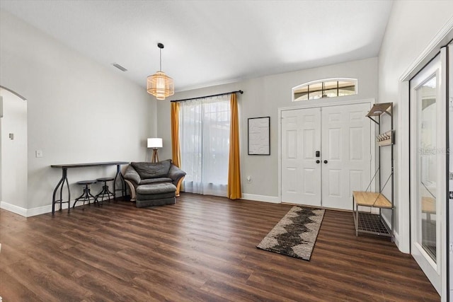 entrance foyer featuring arched walkways, lofted ceiling, wood finished floors, visible vents, and baseboards