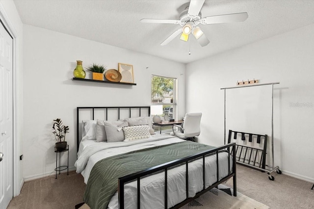 carpeted bedroom featuring a ceiling fan, a textured ceiling, and baseboards