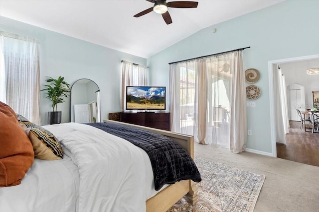 bedroom featuring arched walkways, carpet floors, a ceiling fan, baseboards, and vaulted ceiling