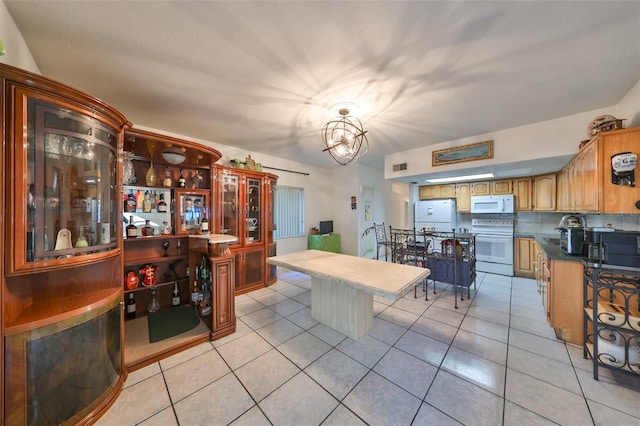 kitchen featuring light tile patterned floors, white appliances, tasteful backsplash, and an inviting chandelier