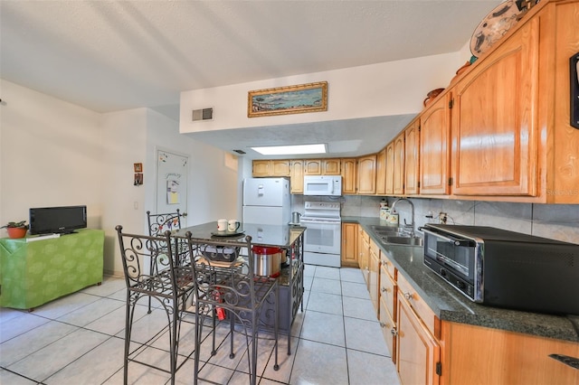 kitchen with white appliances, sink, decorative backsplash, light tile patterned floors, and a textured ceiling