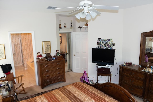 bedroom with ensuite bathroom, light carpet, and ceiling fan