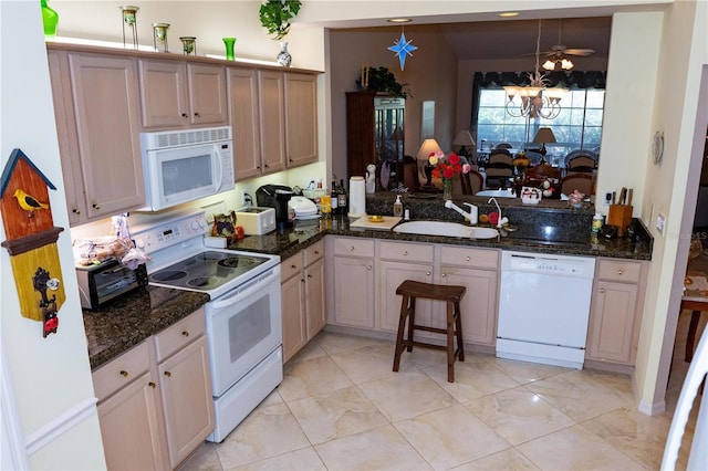 kitchen featuring sink, white appliances, an inviting chandelier, decorative light fixtures, and kitchen peninsula