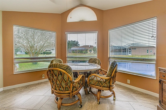 dining space with a wealth of natural light, light tile patterned floors, and lofted ceiling