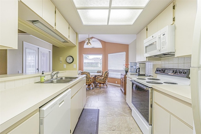 kitchen featuring sink, lofted ceiling, white appliances, decorative backsplash, and light tile patterned floors