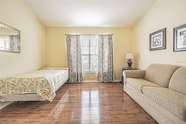 bedroom with dark hardwood / wood-style floors and a textured ceiling